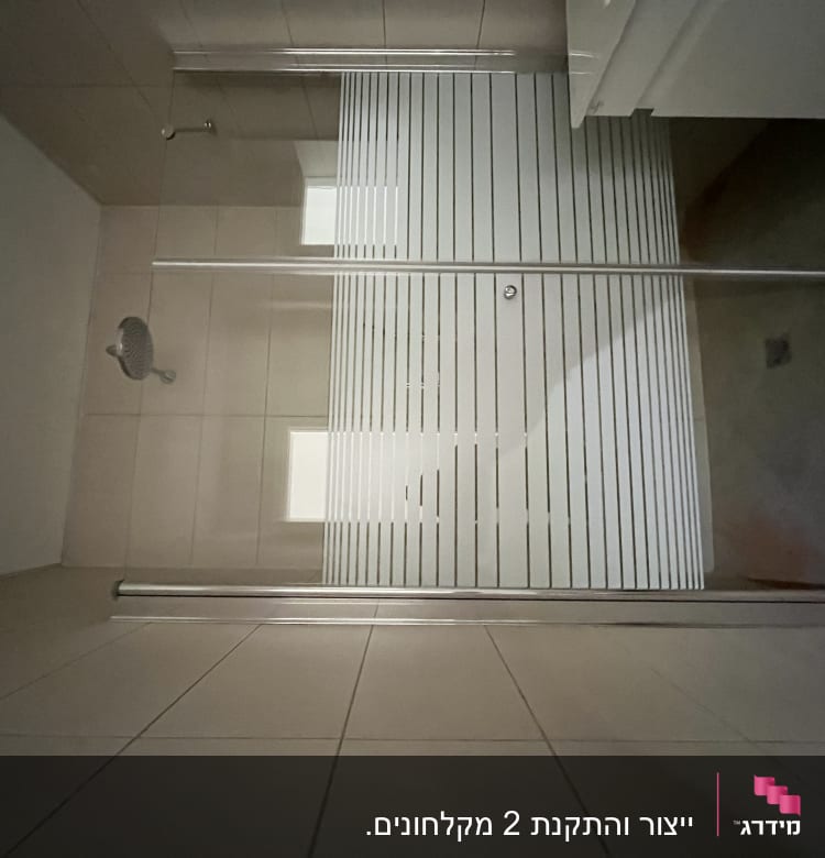 מקלחת עם ראש מקלחת ודלת זכוכית